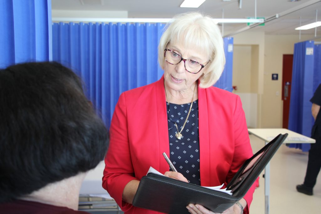 Deb Letica is in a hopsital room, holding a file and speaking to another woman