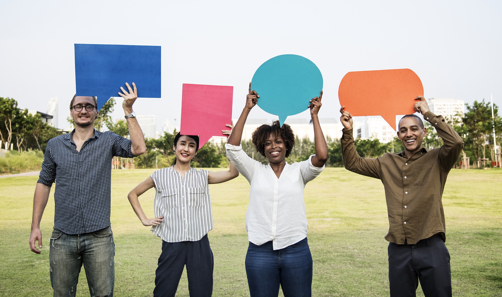 A row of four people holding blank speech bubbles above their heads