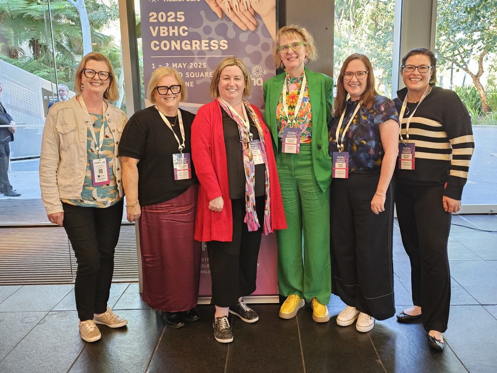 A group shot of 5 women in front of a pull up banner